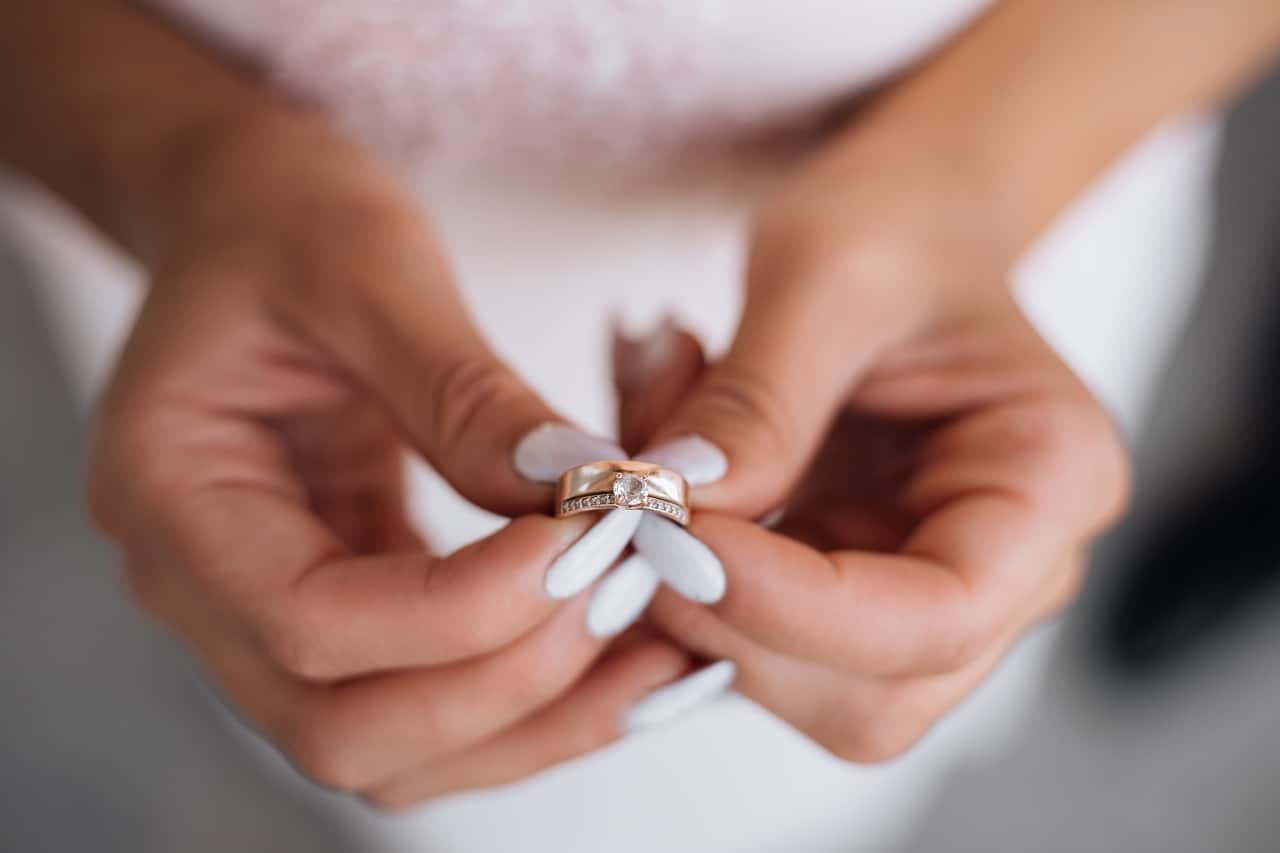 Woman holds precious wedding ring in her arms