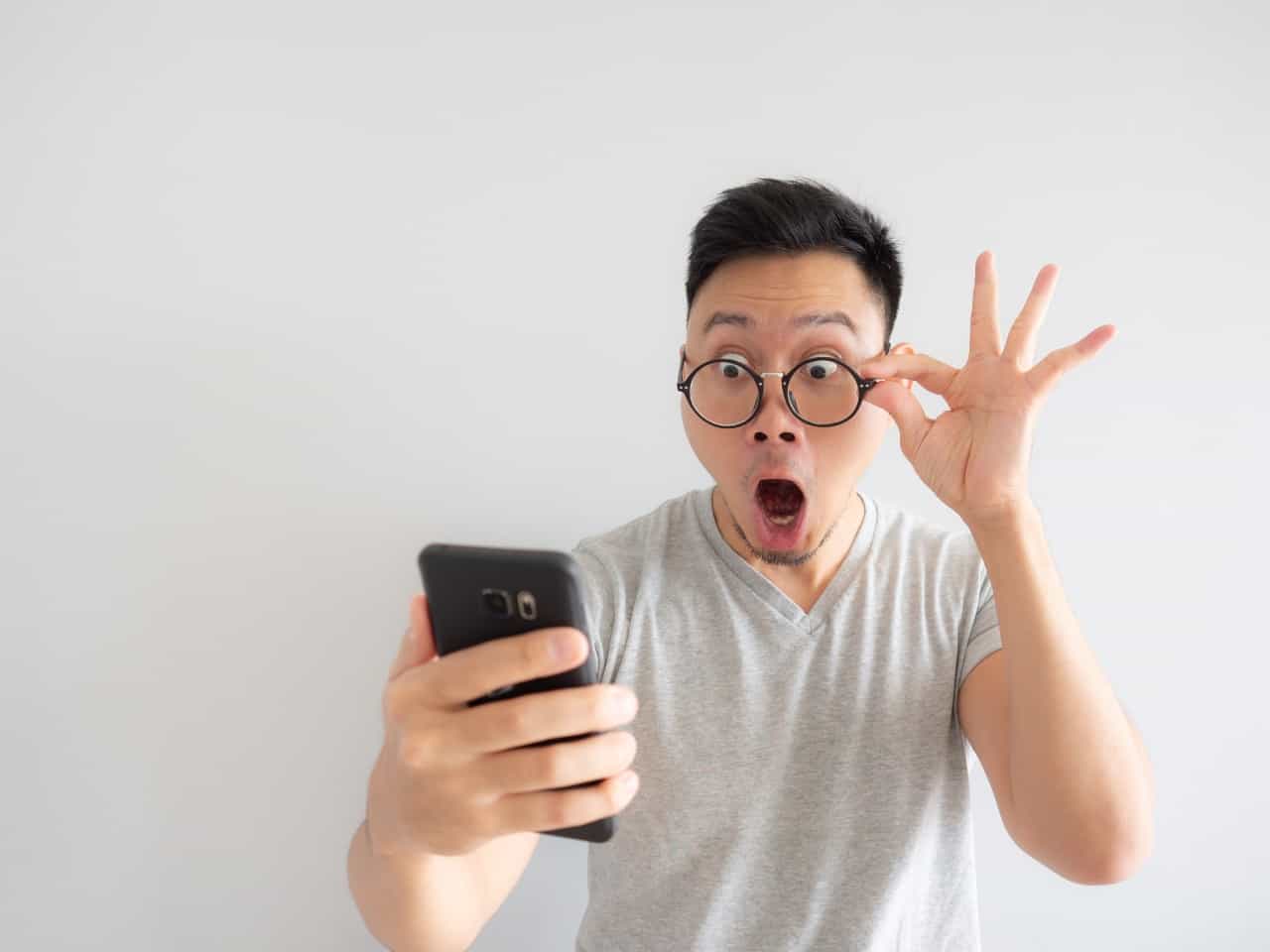 man face shocked seeing his phone