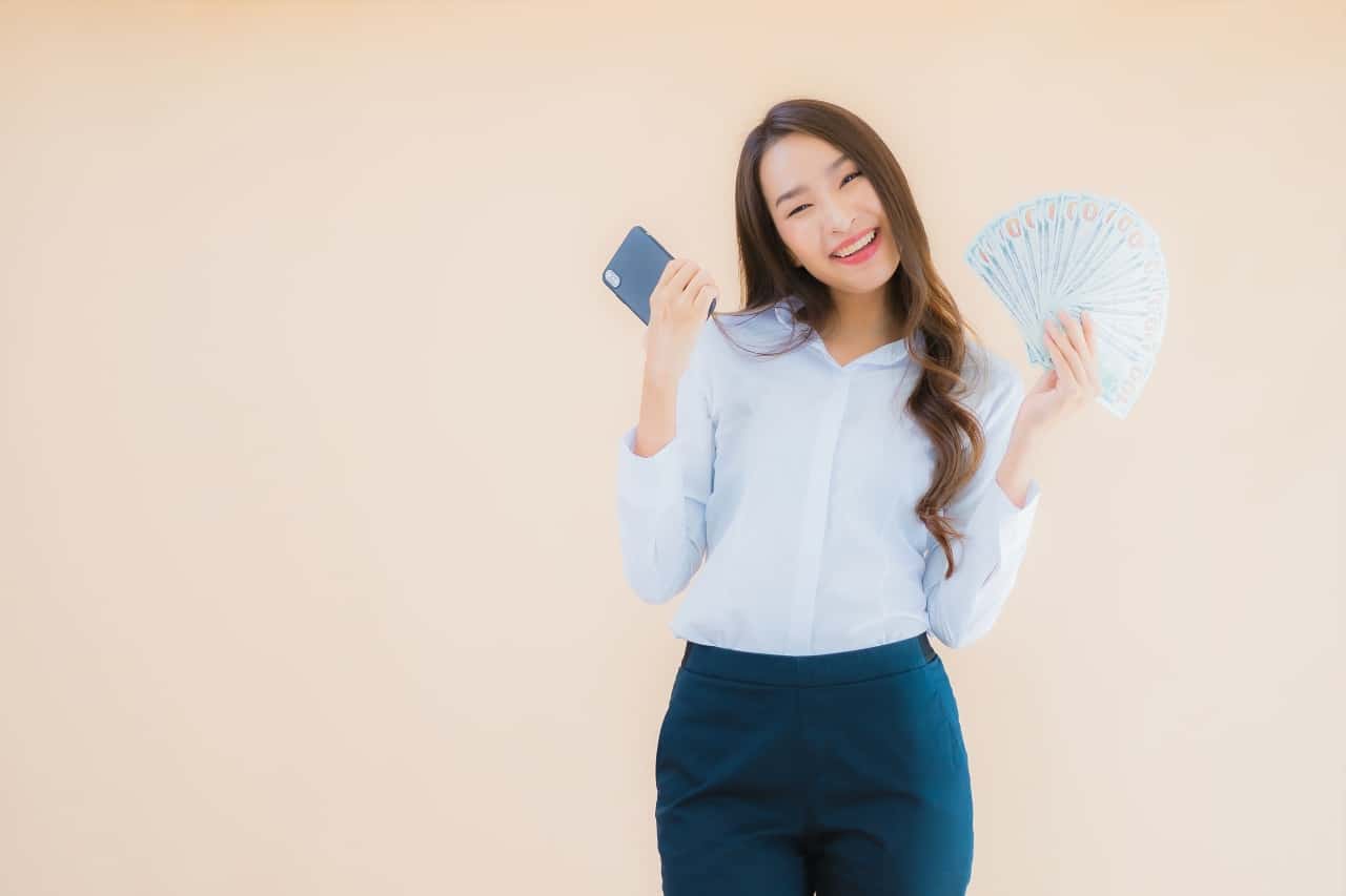 beautiful asian young women holding fan of cash