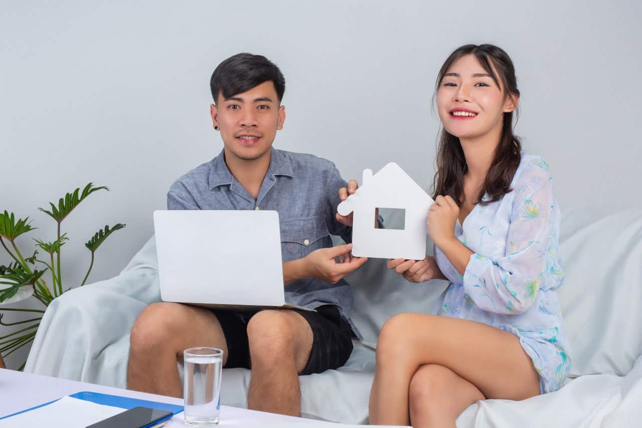 young couple holding house while working from home