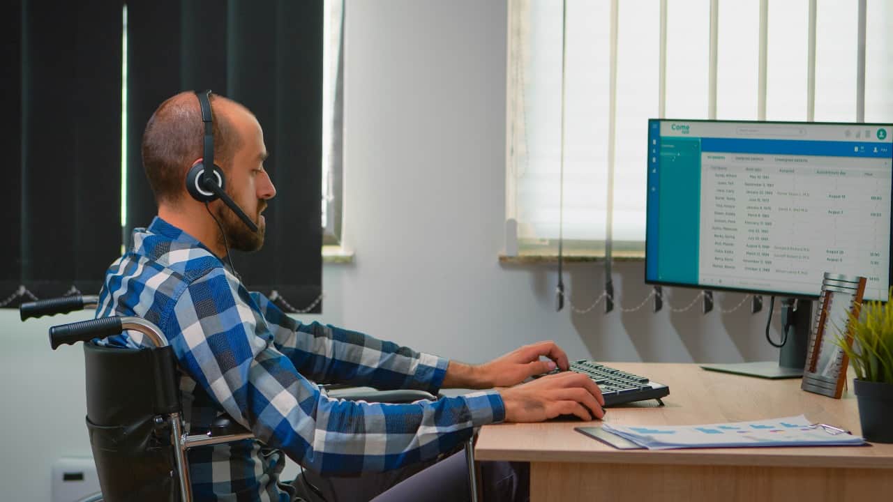 men doing tasks on computer with headphones